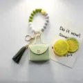 Portachiavi con perline in silicone e mini borsellino in pelle con nappina per borse. - Verde