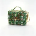 Groene tweed mini opbergtas sleutelhanger, stijlvolle bouclé stof oortelefoon tas met goud. - Groen