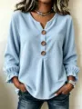 Close-up detail of the light blue corduroy long sleeve shirt featuring V-neck and wooden buttons. - S / Tops / Sky Blue