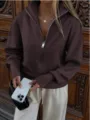 Detailed view of the brown half-zip knitted cardigan featuring a stand collar and relaxed fit. - XS / Tops / Coffee