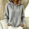 Close up detail of women grey knit hooded sweater with drawstring and ribbed hem features. - S / Tops / Gray