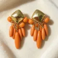 Vintage gold-tone diamond stud with vibrant orange drop bead tassels, close-up view. - Orange Teardrop