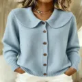 Close-up view of a light blue knitted cardigan featuring a wide collar and brown buttons. - S / Tops / Sky Blue