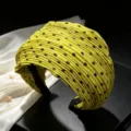 Detailed shot of yellow pleated polka dot wide headband, textured fabric fashion hair accessory. - A Green Polka Dot
