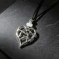 Close-up of silver hollow heart pendant necklace with black cord on dark slate background. - A Hollow Heart