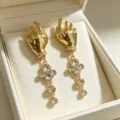 Detailed view of french vintage gold hand shaped dangle earrings with sparkling rhinestones. - Gold Palm Earrings