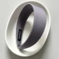 Detailed view of the wide fabric headband in grey, minimalist product photography setup. - Gray