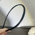 Gros plan détaillé montrant la texture élégante du fin serre-tête minimaliste en cuir PU noir. - Serre-Tête Fin en Cuir PU Noir