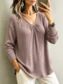 Detail view of the elegant V-neck long sleeve ribbed knit top in a soft mauve color. - Lotus Pink