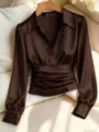 Gros plan détaillé du chemisier marron en satin à manches longues avec taille plissée et col à revers. - S / Hauts / Brun Rouge