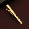 Detailed close-up of a classic gold tie clip with engraved lines and sparkling crystal accent. - Exquisite Line Style (New605)