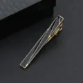 Detailaufnahme einer eleganten goldenen Herrenkrawattenklammer mit schwarzem Streifendesign für Anzüge. - Goldene Geometrische Linien