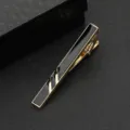 Detailaufnahme einer stilvollen goldenen Herren Krawattenklammer mit schwarzer Geometrie. - Gold Linie Spiral