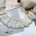 Detailed view of 5.5cm wide ruffled cotton lace trim with butterfly embroidery and blue edge. - 5.5cm / Green Edge