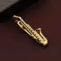Primo piano sul dettaglio del fermacravatta a sassofono dorato, elegante texture metallica per uomo. - Scatola regalo / Sassofono d'Oro