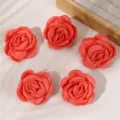 Gedetailleerde close-up van vijf rode stoffen rozenhaarspelden voor herfst en winter. - Roze