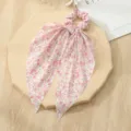 Gedetailleerd uitzicht op de roze haarrekkers met bloemenprint en lange mesh linten stijl. - Roze