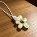 Resin flower pendant necklace close up, white woven cord, vacation style jewelry detail view. - Off-white Floral