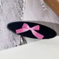 Primer plano de una horquilla ovalada negra con lazo rosa, accesorio de pelo bonito. - Lazo Grande Rosa