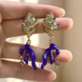 Golden conch stud earrings with blue enamel coral drops and sparkly rhinestone details. - Blue Coral