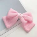 Close-up van roze gebreide strik haarklem, fijn geweven textuur detail, elegante haaraccessoire - Roze