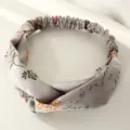 Gros-plan sur le bandeau en tissu fleuri vintage avec nœud torsadé et élastique au dos. - Gris