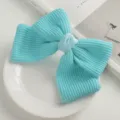 Cute knitted bow hair clip in vibrant turquoise color, elegant hair accessory for women detail shot. - Blue