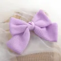 Close-up detail of a charming light purple woven bow hair clip with soft fabric texture. - Purple