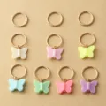 Close-up detail of colorful resin butterfly hair braid rings and metal hoops. - Butterfly Hair Accessories Set / Colorful