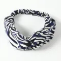Close-up detail of the blue and white abstract print twist headband with elastic back design. - Blue