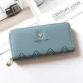 Vista dettagliata del portafoglio lungo con zip azzurro con dettaglio a cuore e motivo a zigzag. - Azzurro