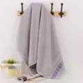 Grey cotton bath towel with wide satin border, soft and absorbent home textile essential. - Gray