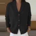 Detail view of a cozy black knitted cardigan featuring a classic shawl collar and front button closure. - S / Tops / Black