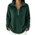 Primo piano del colletto con zip in pile a coste verde scuro e dettagli di tessuto. - Verde