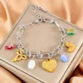 Dettaglio del bracciale con ciondoli bicolore in acciaio inox con perle di cristallo e cuori. - Cuore Pressato ad Olio