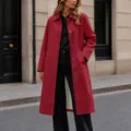 Gros plan détaillé du élégant trench-coat rouge à simple boutonnage et col à revers. - Rouge