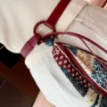 Stylish women's red leather belt with vintage floral printed silk scarf accessory detail. - Red