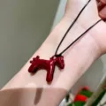 Closeup view of a cute enamel little horse pendant necklace showcasing fine details and texture. - Burgundy Pony Pendant Necklace