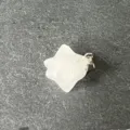 Primo piano di un ciondolo stella merkaba in cristallo bianco con gancio in metallo su ardesia. - Cristallo di rocca