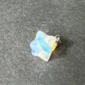Nahaufnahme Detail des synthetischen Opal Merkabah Sternanhangers auf dunklem Stein. - Synthetischer Opal