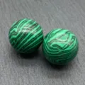 Close-up detail of natural green malachite gemstone sphere showcasing unique vibrant banding. - Malaysian Jade