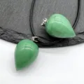 Detailed close-up of green teardrop stone crystal pendant on black cord necklace. - Green Aventurine