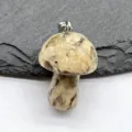 Detailed shot of a natural stone miniature mushroom pendant with a silver bail, gemstone charm. - Yellow Turquoise