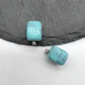 Close-up detail view of small square turquoise pendant stone with silver bail for necklace. - Synthetic Turquoise