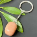 Close-up detail of natural crystal tumbled stone keychain with stainless steel ring and polished gem. - 15-20mm Tumbled Stone / Pink Aventurine Keychain