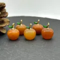 Detail view of natural stone apple charms, crystal agate pendants for DIY jewelry making. - Red Aventurine