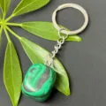 Detailed close-up shot of the natural malachite tumbled stone keychain with stainless steel ring. - 15-20mm Tumbled Stone / Synthetic Malachite Keychain