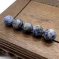 Detailed close-up shot of natural blue spot stone round beads for DIY jewelry making parts. - Blue Spot Jasper