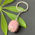Close-up detail of a polished natural pink crystal stone keychain with stainless steel ring. - 15-20mm Tumbled Stone / Rhodonite Keychain
