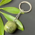 Detail shot of natural green crystal tumbled stone pendant keychain with stainless steel hardware. - 15-20mm Tumbled Stone / Serpentine Jade Keychain